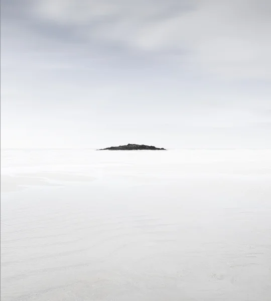 Водные скалы и песчаный пляж на закате — стоковое фото